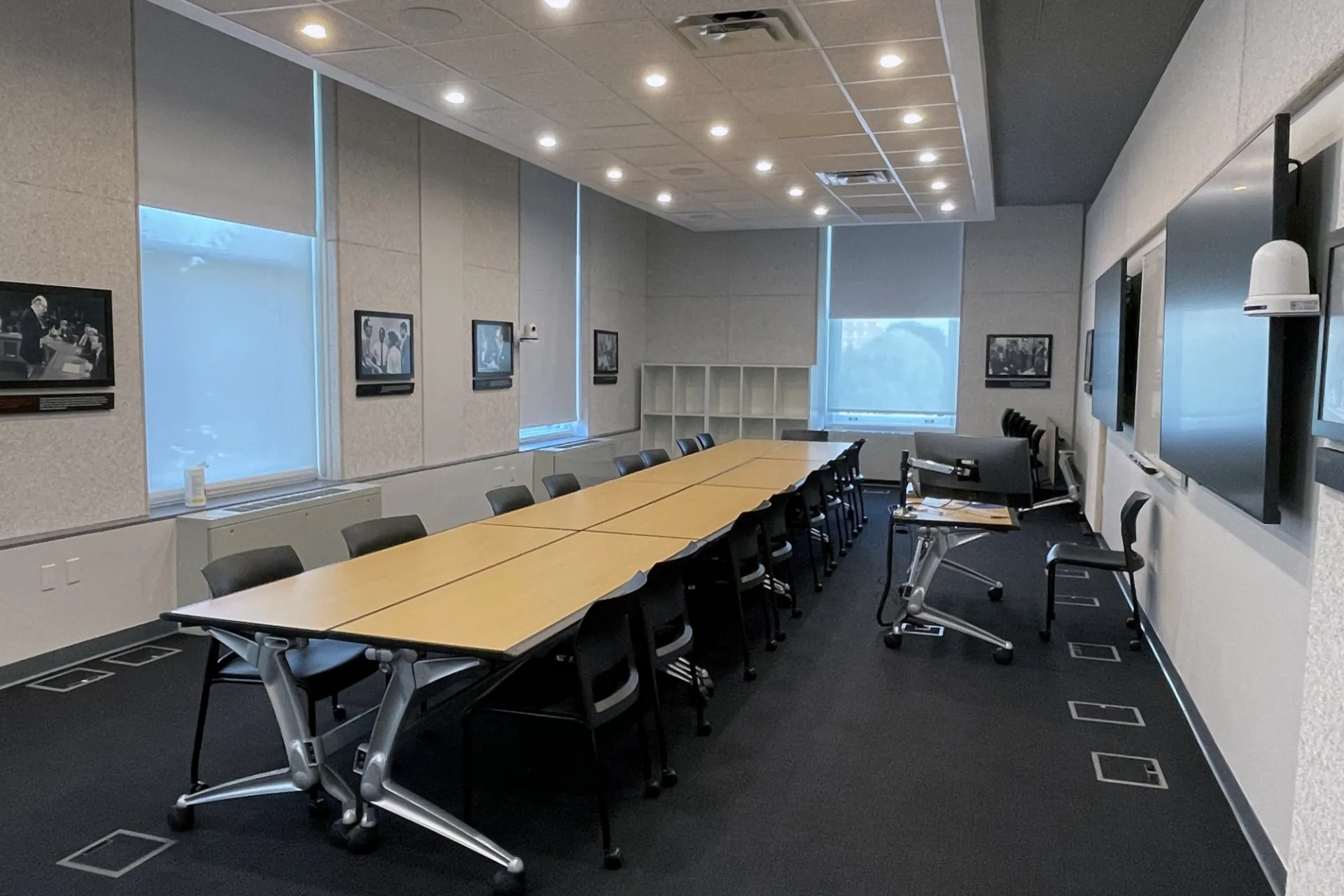 A classroom with several tables pushed together to form one long conference table in a classroom.